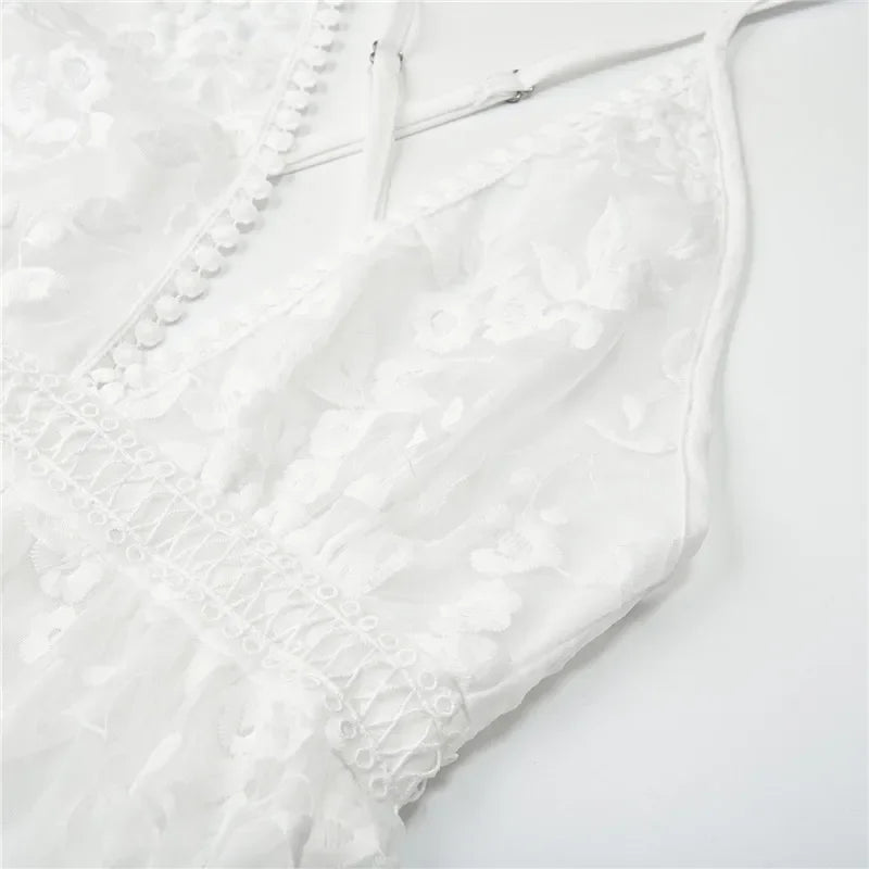 Détail de la dentelle florale de la robe mini blanche